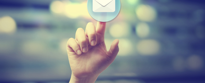 Hand pressing an email icon on blurred cityscape background